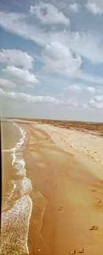 Scenic view of beach against cloudy sky