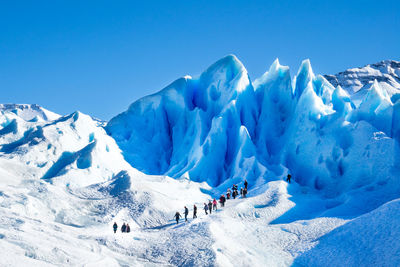 Panoramic view of snowcapped mountains against blue sky