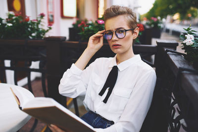 Portrait of young man using smart phone while sitting on table