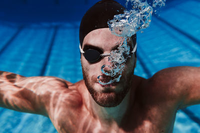 Midsection of shirtless man in swimming pool