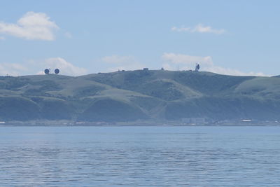 Scenic view of sea and mountains against sky