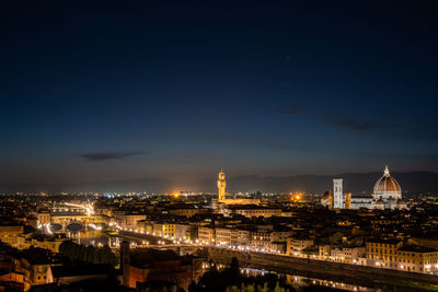 Illuminated cityscape against sky at night