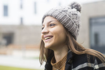 Portrait of smiling young woman looking away outdoors