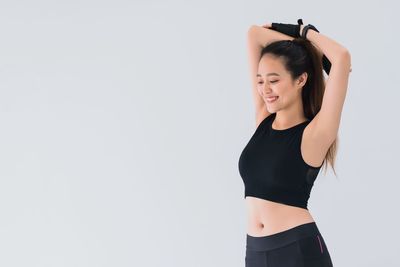 Young woman standing against white background