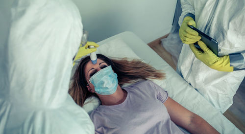 High angle view of doctors examining female patient in hospital