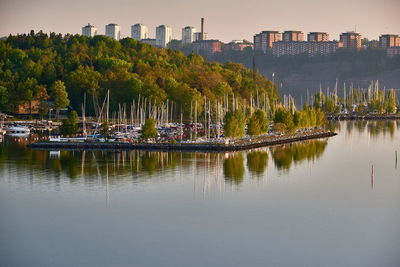 Boats in lake against buildings in city