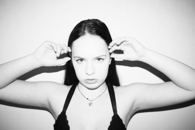 Close-up portrait of teenage girl gesturing against wall