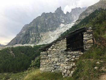 Scenic view of building and mountains against sky