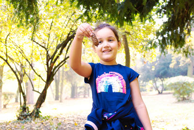 Portrait of smiling girl against trees