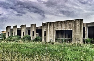 Built structure on field against cloudy sky