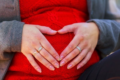 Midsection of pregnant woman touching stomach