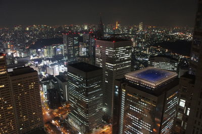 Illuminated cityscape against sky at night