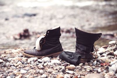 Close-up of shoes at beach