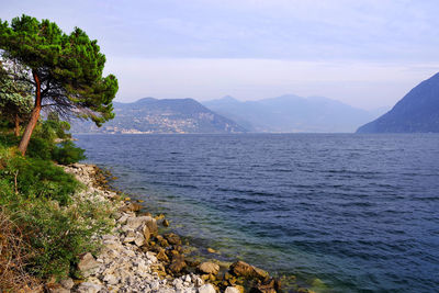 Scenic view of sea and mountains against sky