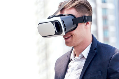 Smiling businessman virtual reality in city