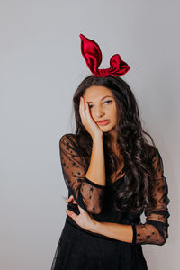 Portrait of beautiful woman standing against red background