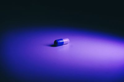 High angle view of illuminated lamp on table against blue background