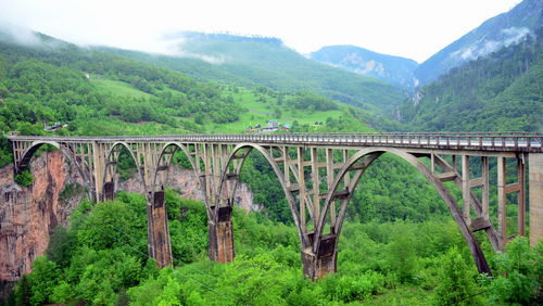 Bridge over mountains against sky