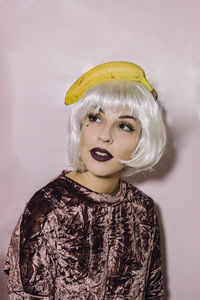 Portrait of young woman with banana on head