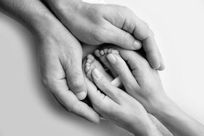 Cropped hands of baby against white background