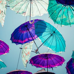 Low angle view of umbrellas hanging against sky