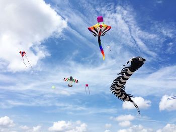 Low angle view of kites flying against sky