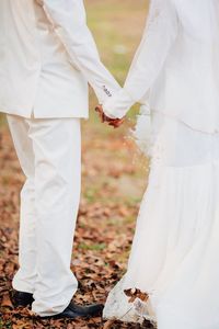 Rear view of bride and groom holding hands