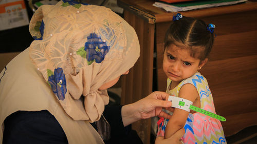 Nurse examining girls arm