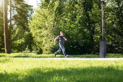 A male blond criminal runs away from the scene of the attack in the city park.