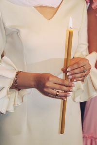 Midsection of woman holding candle at church