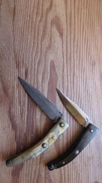 High angle view of knives on wooden table