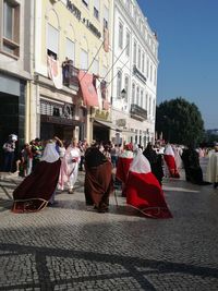 People walking on street against buildings in city