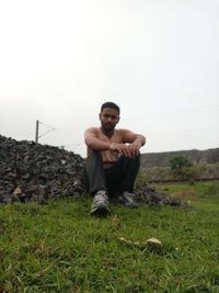 Portrait of young man sitting on field