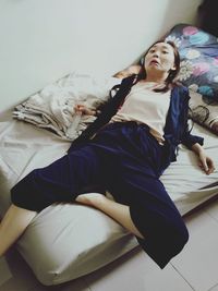 Woman lying on bed at home