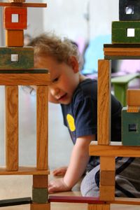 Side view of baby boy playing with toy blocks at home