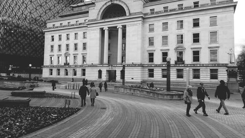 People walking by baskerville house in city