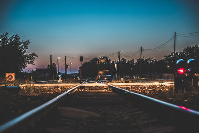 Railroad tracks against sky at night