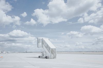 Airplane on airport runway against sky