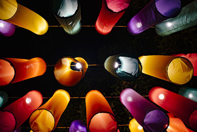 Low angle view of multi colored lanterns hanging outdoors at night