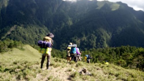 People on mountains against plants on mountain