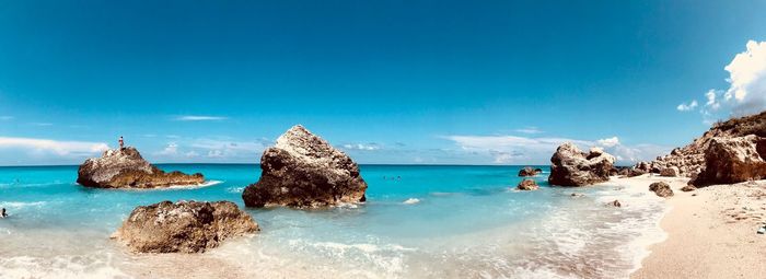 Panoramic view of rocks on sea against blue sky