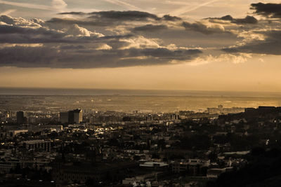 High angle view of city buildings against sky during sunset