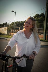 Portrait of smiling young woman walking with a bicycle