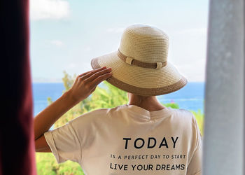 Rear view of woman wearing hat standing against sky