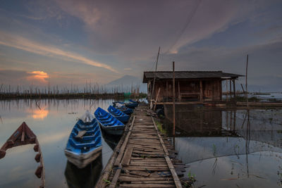 Wooden posts in water at sunset