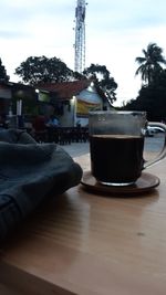 Coffee cup on table against sky