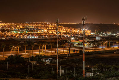 High angle view of illuminated buildings against sky at night