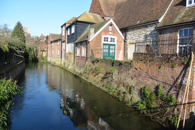 Canal amidst old buildings against sky