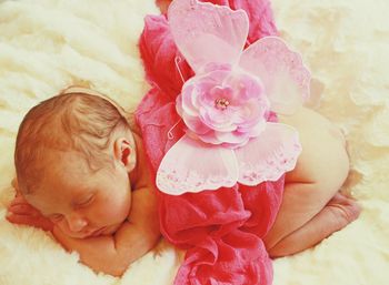 Cute baby girl with prop lying on bed