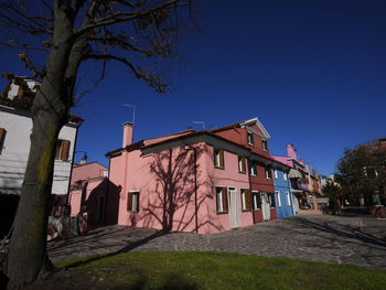 Low angle view of buildings against clear blue sky